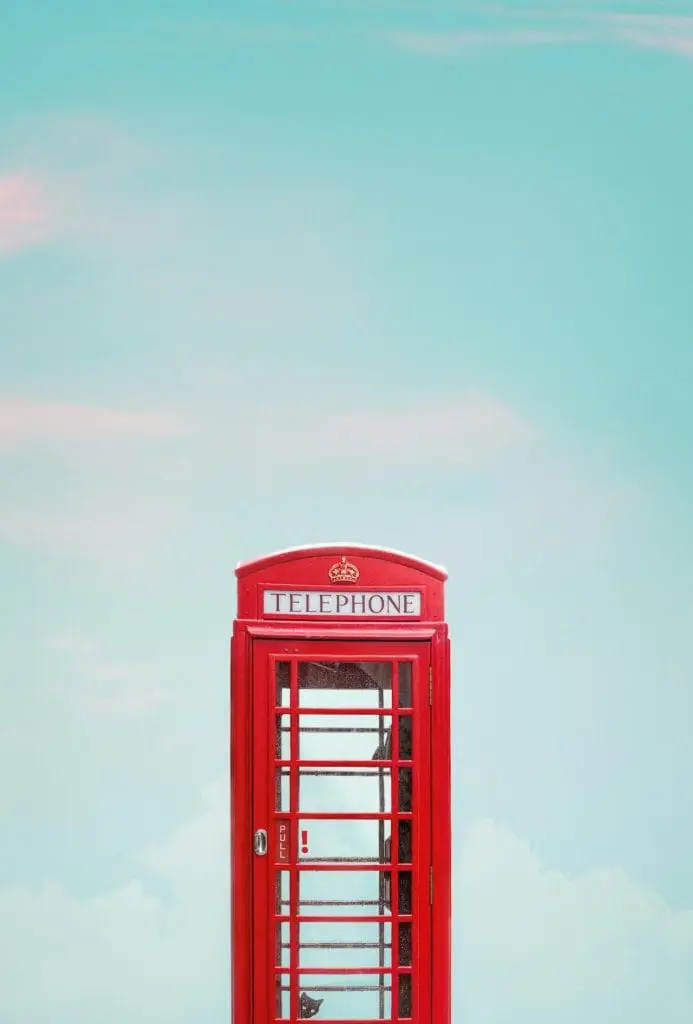 a red telephone booth with a blue sky in the background