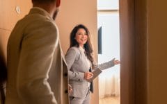 Young businessman check-in in hotel, smiling female receptionist  showing him available rooms.